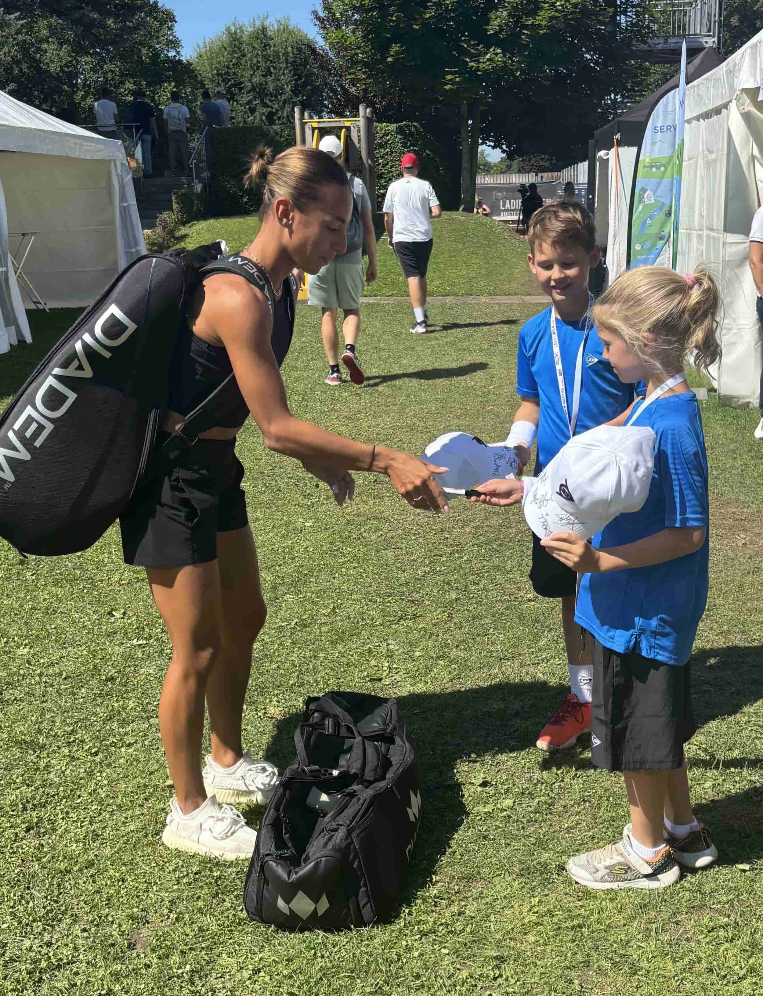 Das Salzburger Tennis-As Arabella Koller unterschreibt zwei Kindern auf LADIES OPEN Merchandising.
