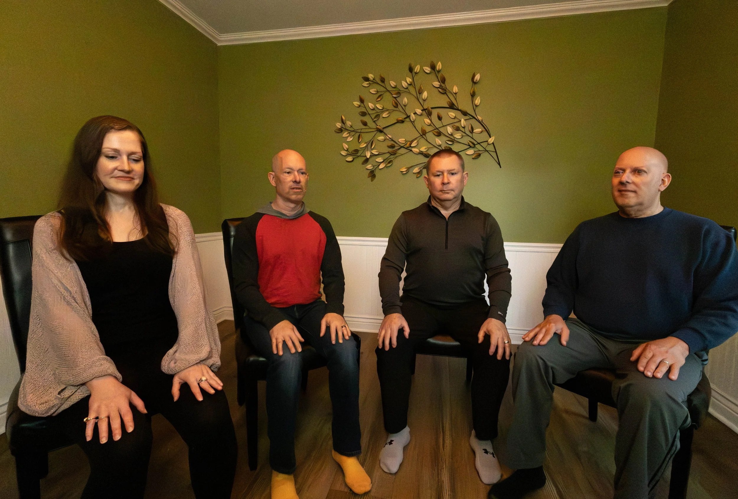 Image of four people in seated meditation in chairs.