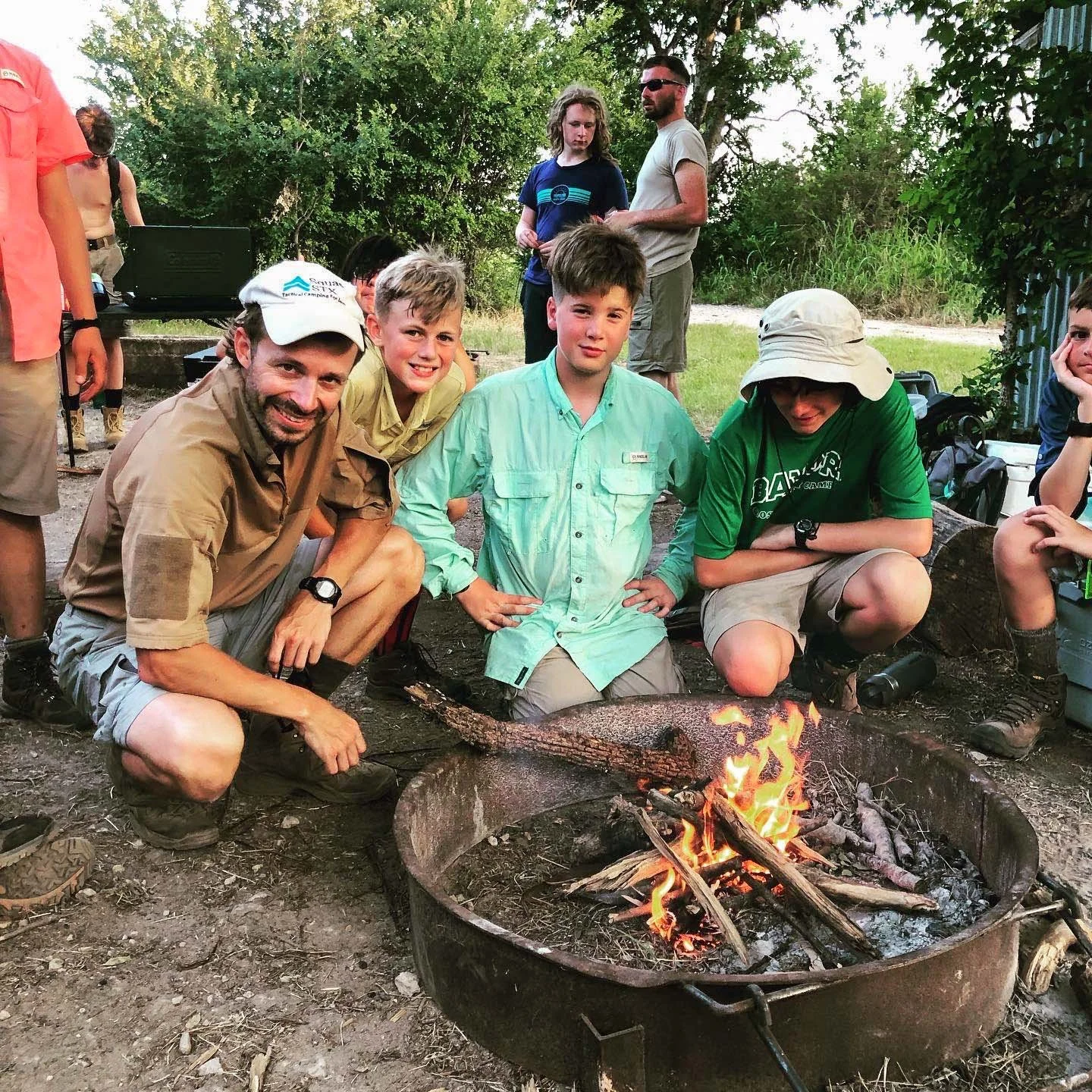 Happy campers gather around campfire they built.