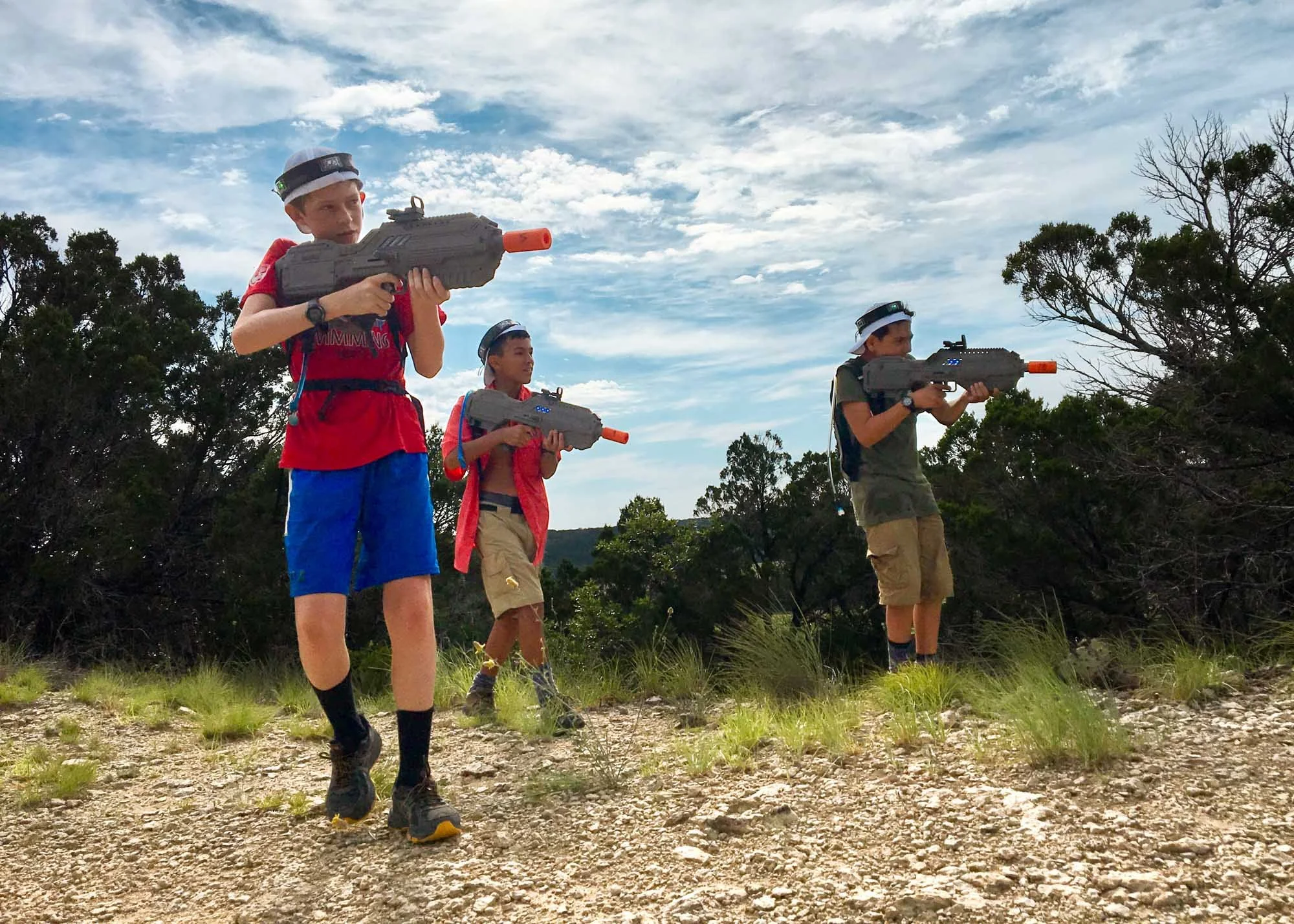 Campers aiming their laser tag guns during a game of capture the flag.