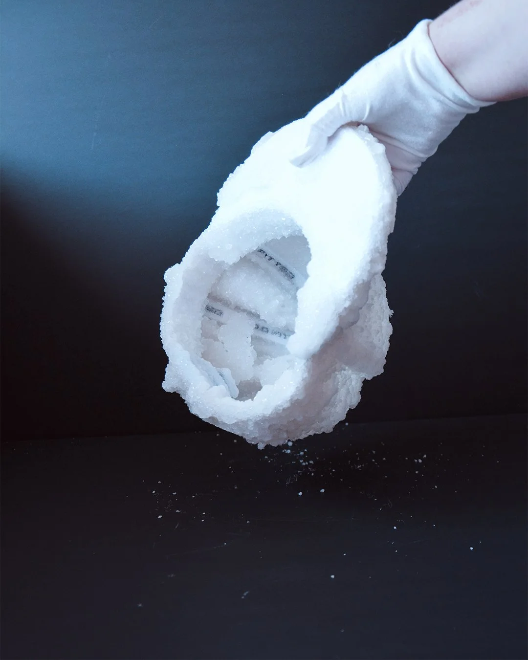One hand holding the crystal cap to show the side and the inside