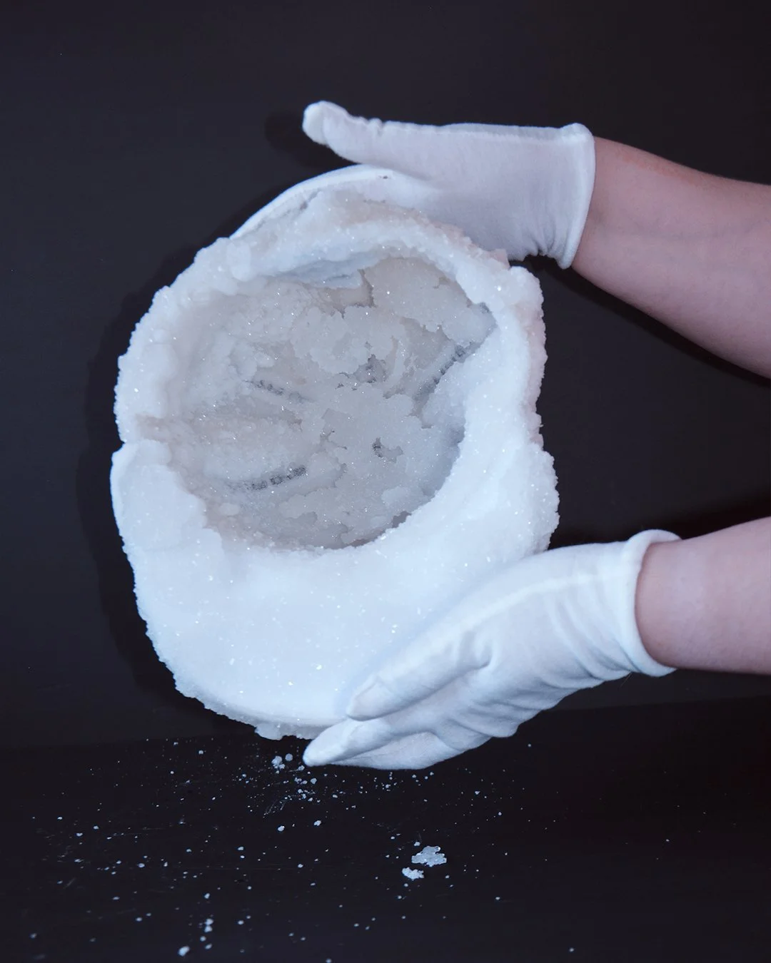 two hand holding the crystal cap to show the inside