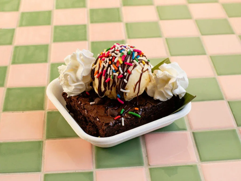 Classic fudge brownie sundae with chocolate chips, sea salt, ice cream, hot fudge, rainbow sprinkles, and whipped cream