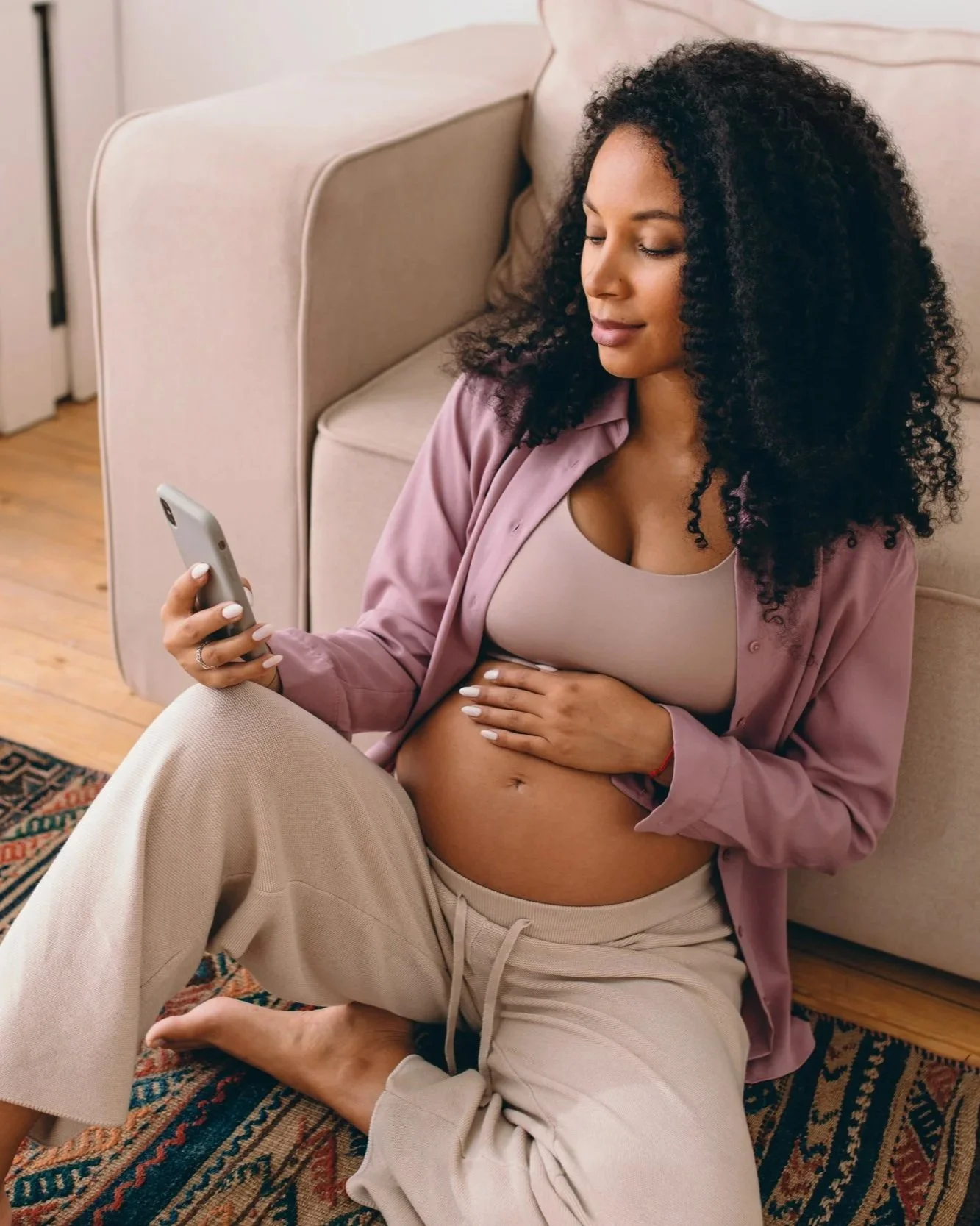 Pregnant mom at home researching breastfeeding support on her phone