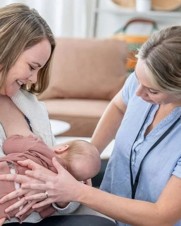 Lactation consultant helping new mom breastfeed newborn in private practice setting