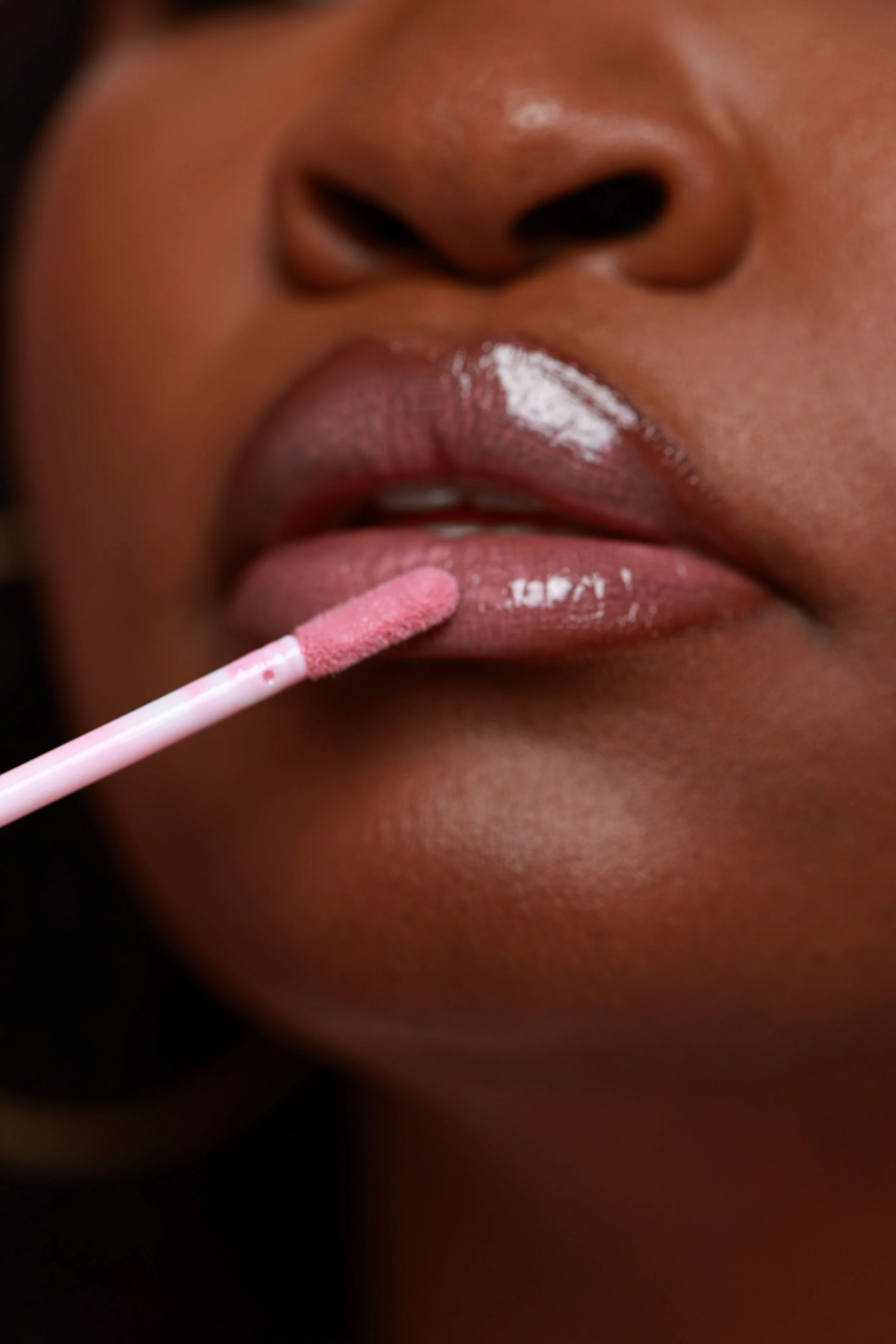 Sweet lip gloss being applied to lips.