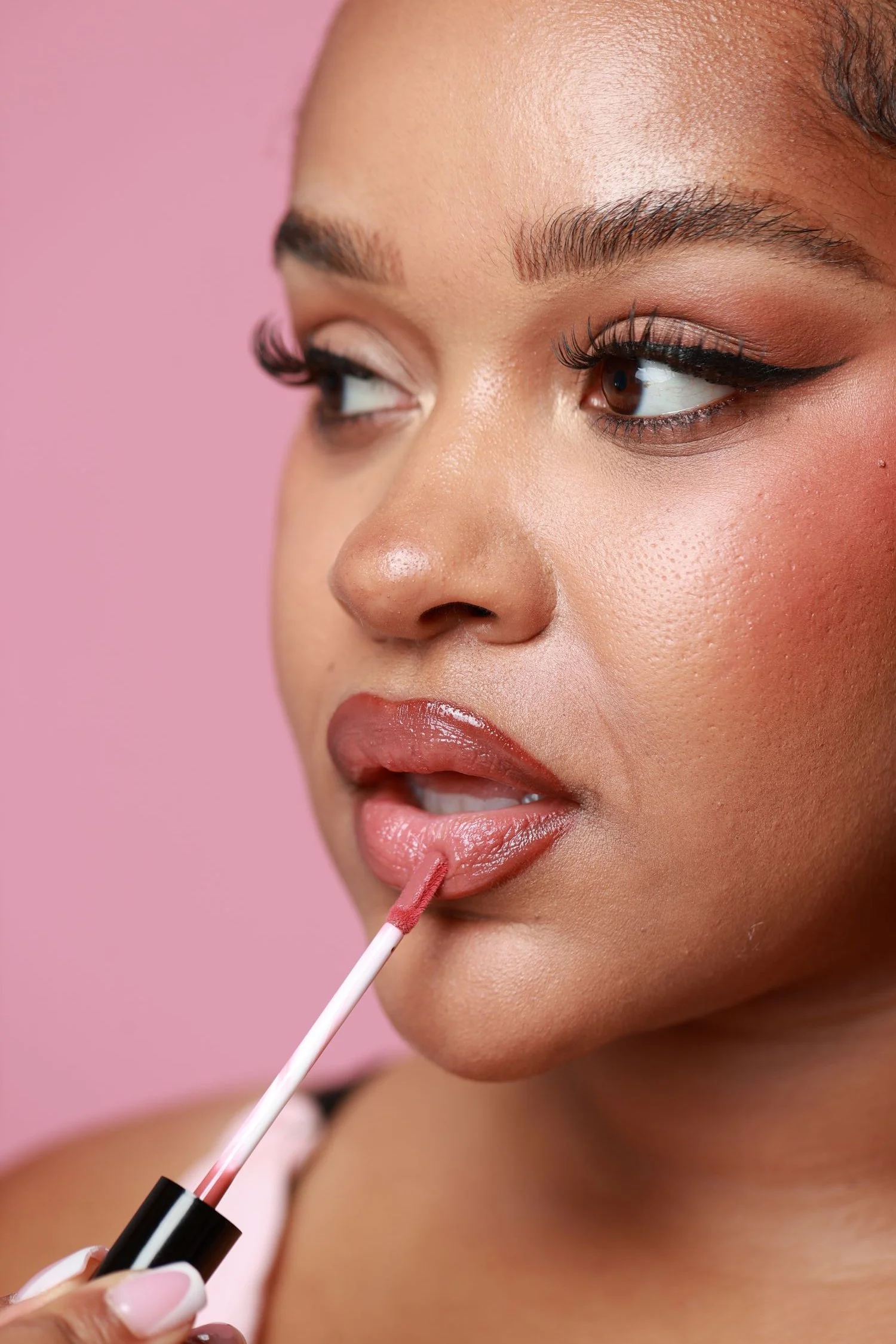 Model's face, applying Starry lip gloss.