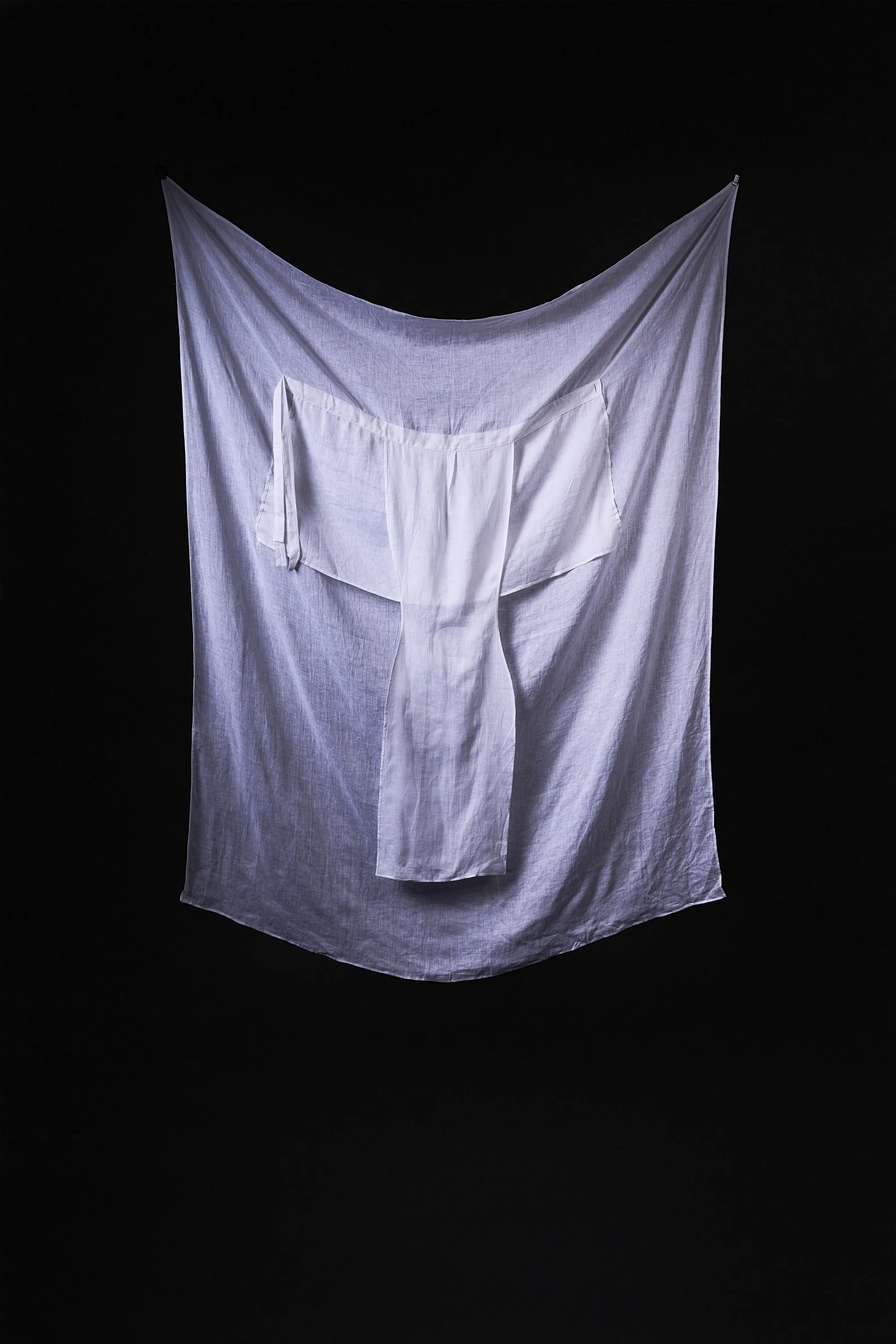 White fabric hanging on a black background