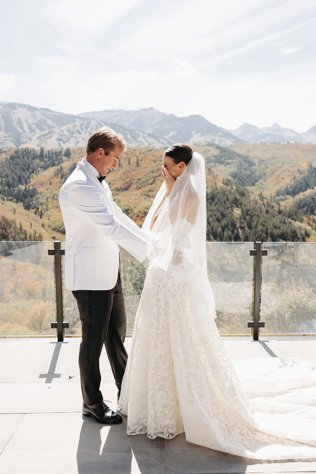 A bride and groom exchanging vows on a balcony with mountain views in the background.