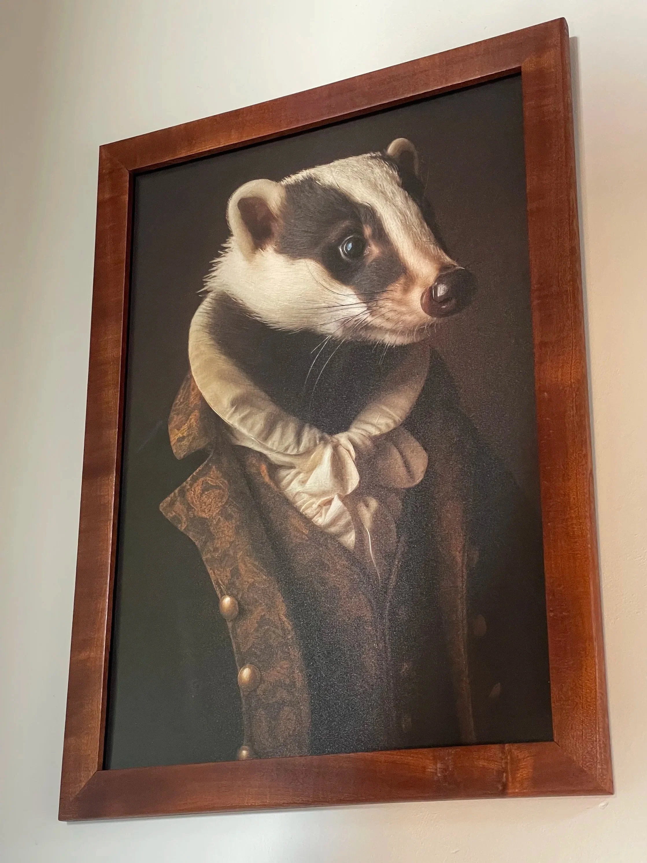 Framed portrait of a badger dressed in Renaissance-style clothing with a ruffled collar, set against a dark background.