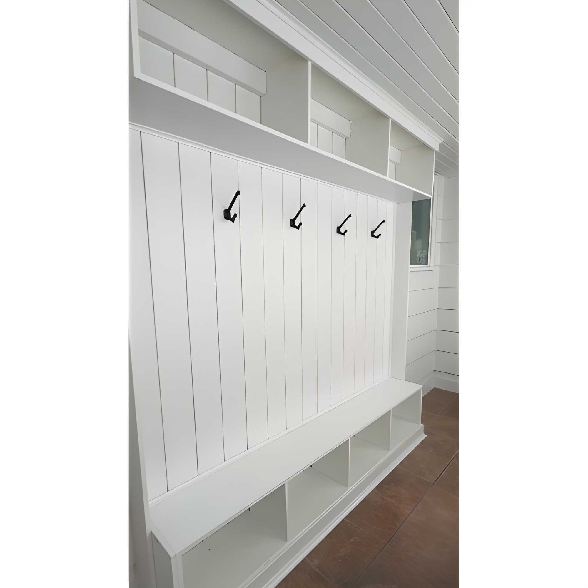 A white shelving unit with coat hooks against a wall, located in a room with tiled flooring. Azure Interiors Southwestern Ontario.