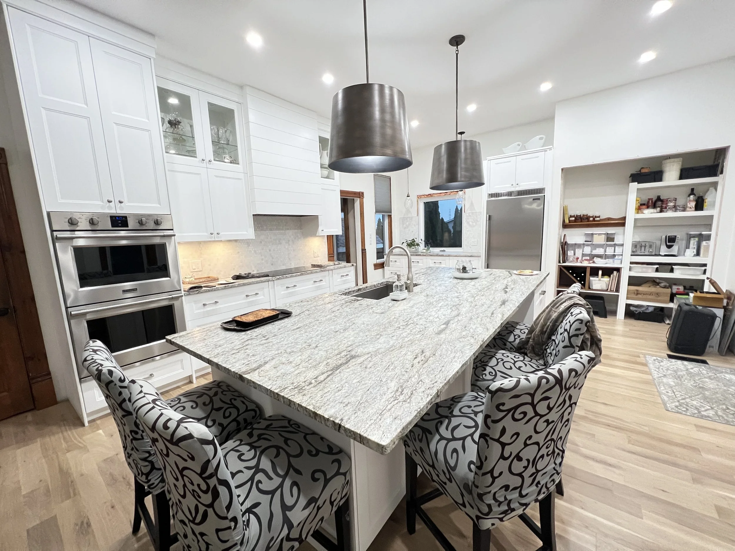White cabinetry, a generous island and dark pendant lights give this kitchen room for cooking and catching up.