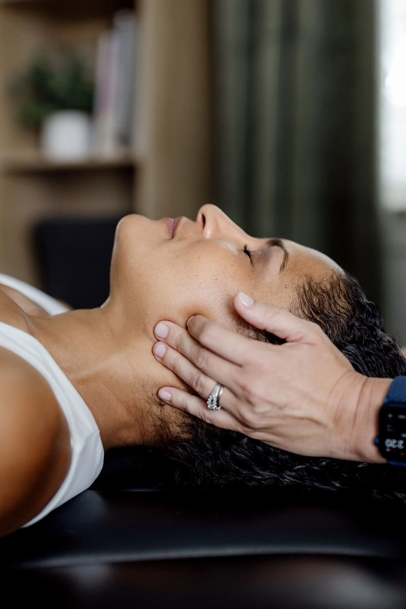Person receiving a neck massage from another person, with a focus on the person's head, neck, and shoulder area.