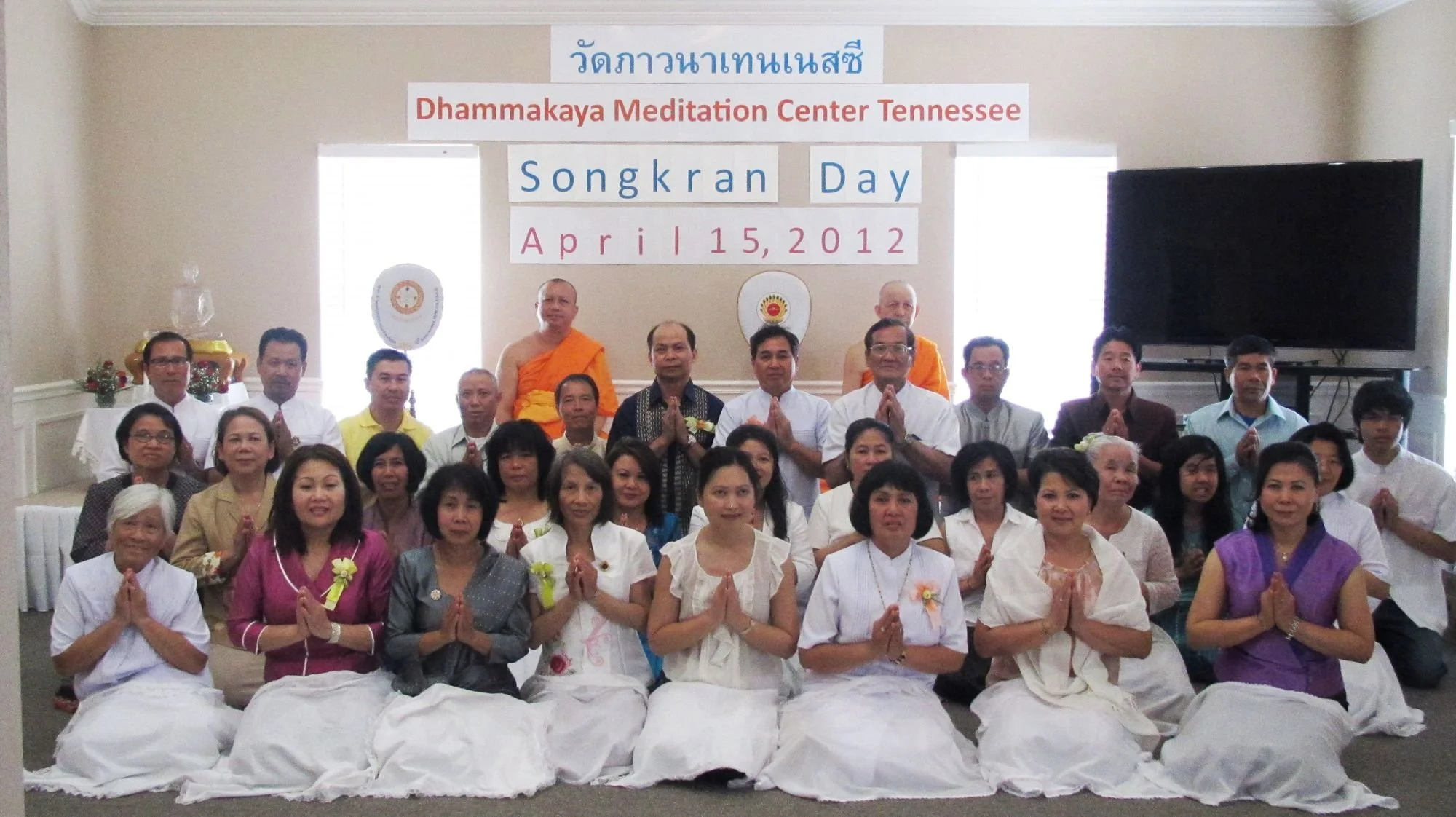 A large group of people, including monks and women in traditional attire, gathered for a photo during Songkran Day at Dhammakaya Meditation Center Tennessee on April 15, 2012.