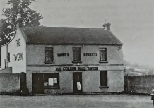 An old black-and-white photo of a two-story building with signs for a countryside milk tavern, showing a storefront with windows and a door, and the words 'The Open,' 'Milk,' and 'Spirits' visible on the facade.