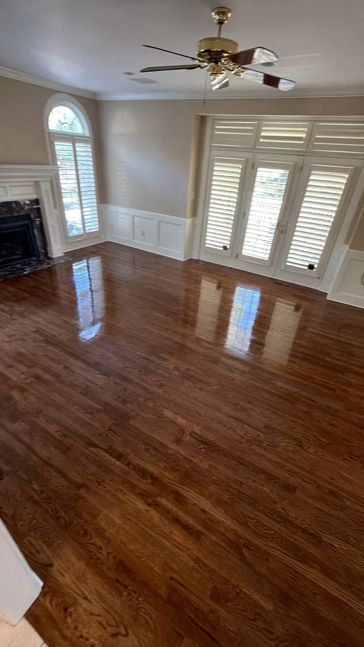 Finished hardwood floor in a Brookside living room with a fireplace and French doors