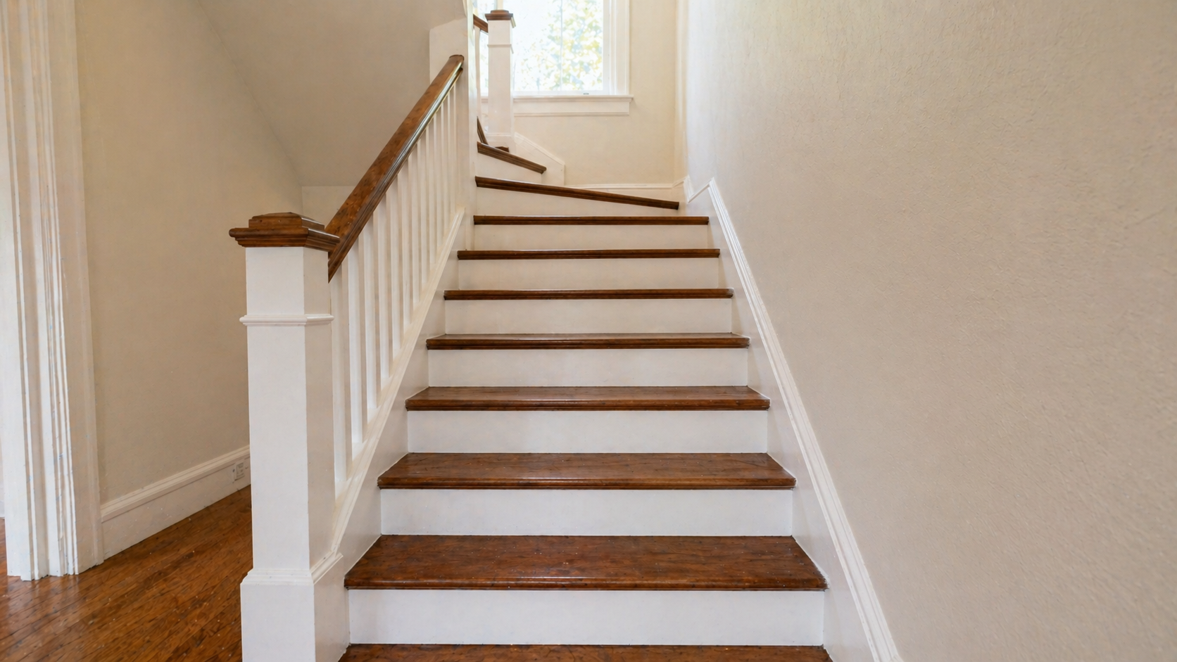 Refinished staircase with stained red oak treads and white painted risers in a Kansas City home