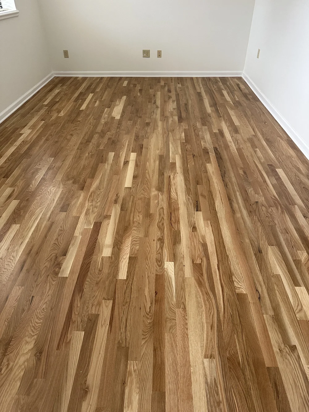 Restored hardwood with varied board tones in a Prairie Village home