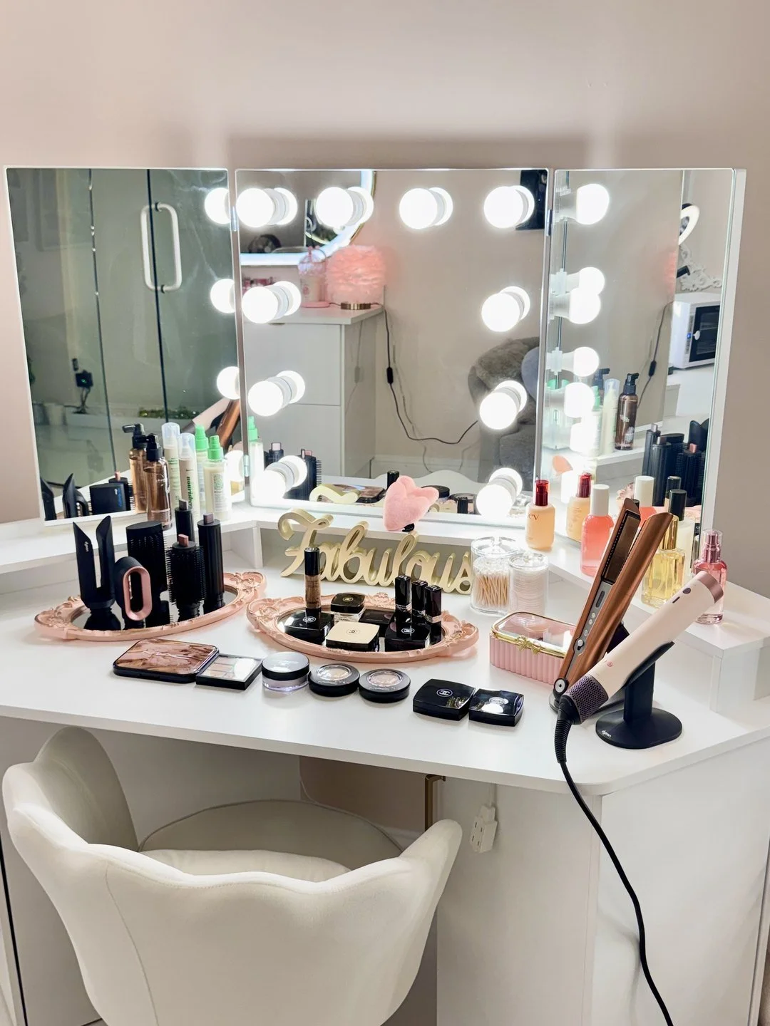 A makeup station with lit mirrors, brushes and styling tools