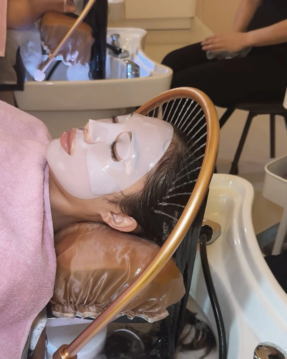 A guest receiving a head spa treatment at the basin