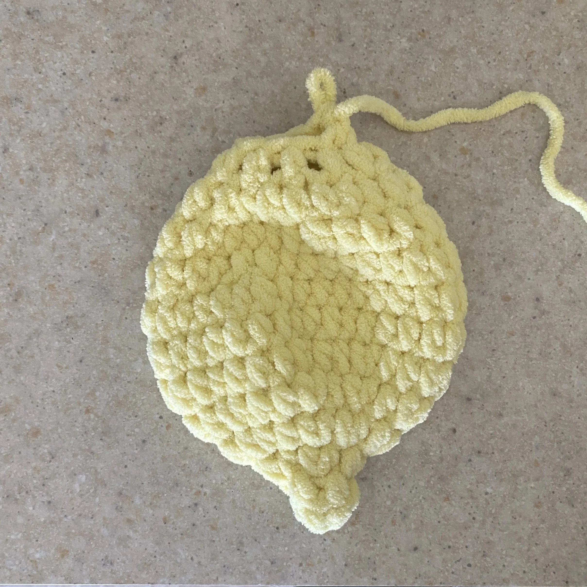 Close-up crochet progress photo showing the plush yellow lemon body construction for the Lila the Lemon Lovey crochet pattern before closing and assembly.