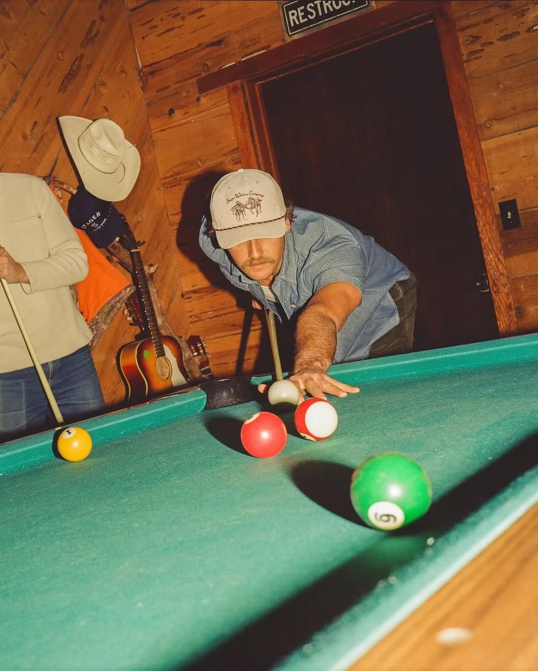 one guy playing pool at a bar