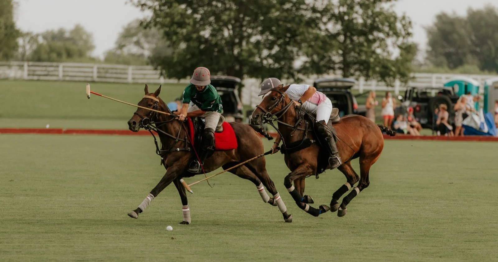 Two polo players during a game at Arranmore Farm + Polo Club they are on horses- one is a woman