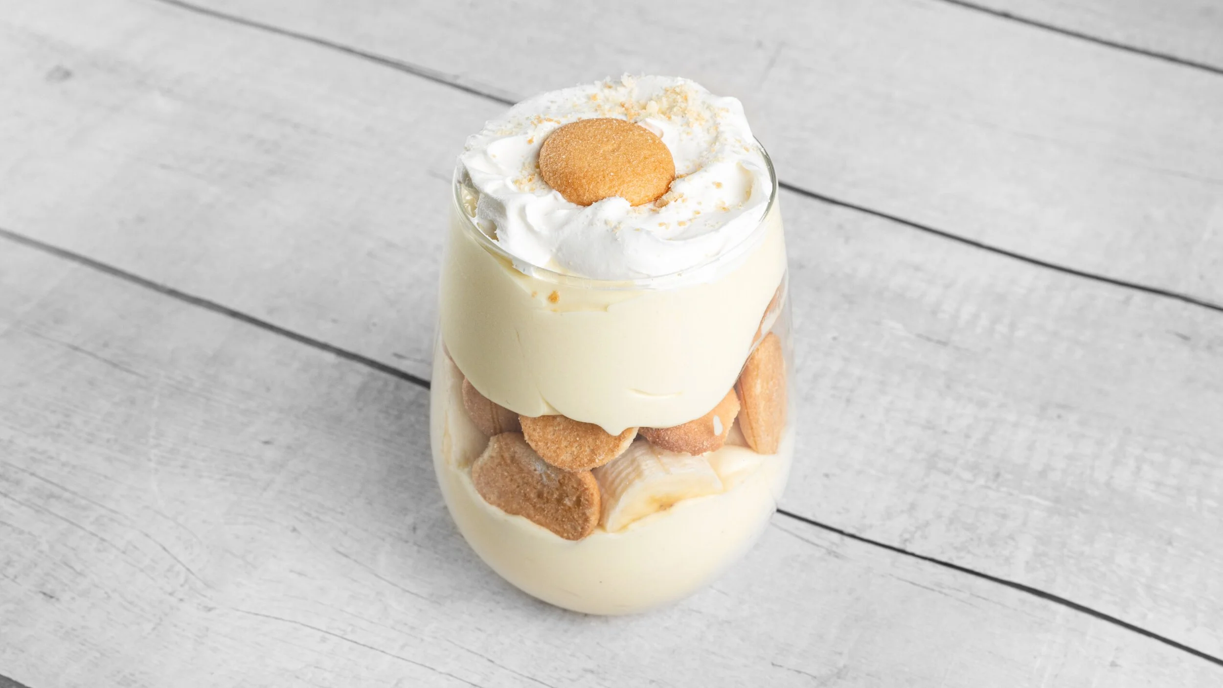 Creamy homemade banana pudding layered with vanilla wafers, smooth pudding, and whipped cream from Palate Bomb in Miami Gardens.