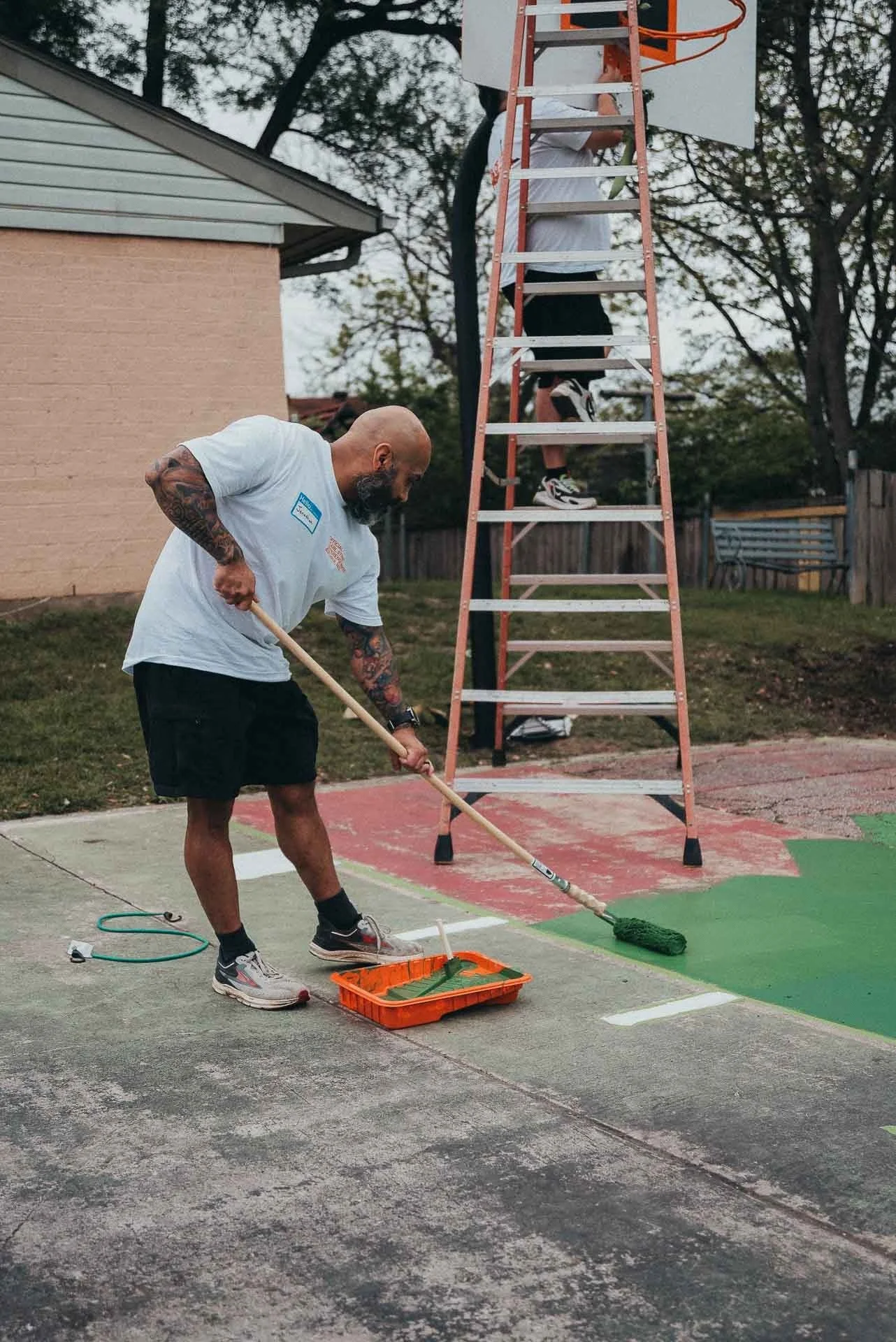 Pearl Street Church volunteer repainting a neighborhood basketball court during a serve day