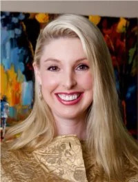 Jennifer LaFleur, an attorney with long blonde hair, smiling with white teeth, wearing a gold dress, standing in front of a colorful abstract background.