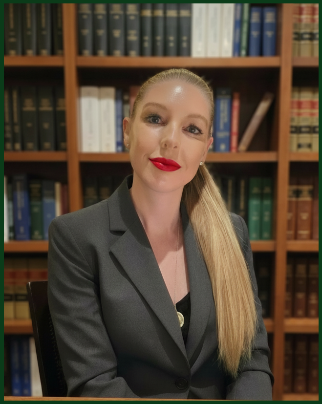 A photo of Jennifer LaFleur, a Collin County family attorney, wearing a gray blazer, sitting in front of a bookshelf filled with hardcover books.