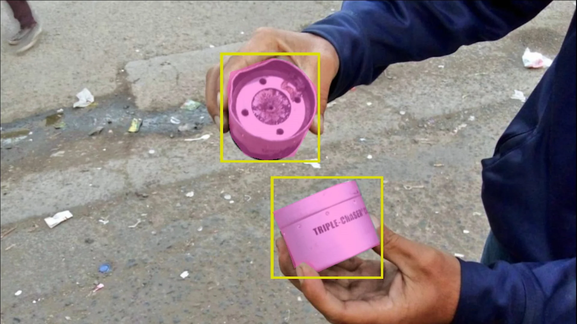 Person holding tear gas canisters labeled 'TRIPLE-CHASER' highlighted in pink and outlined in a yellow box.