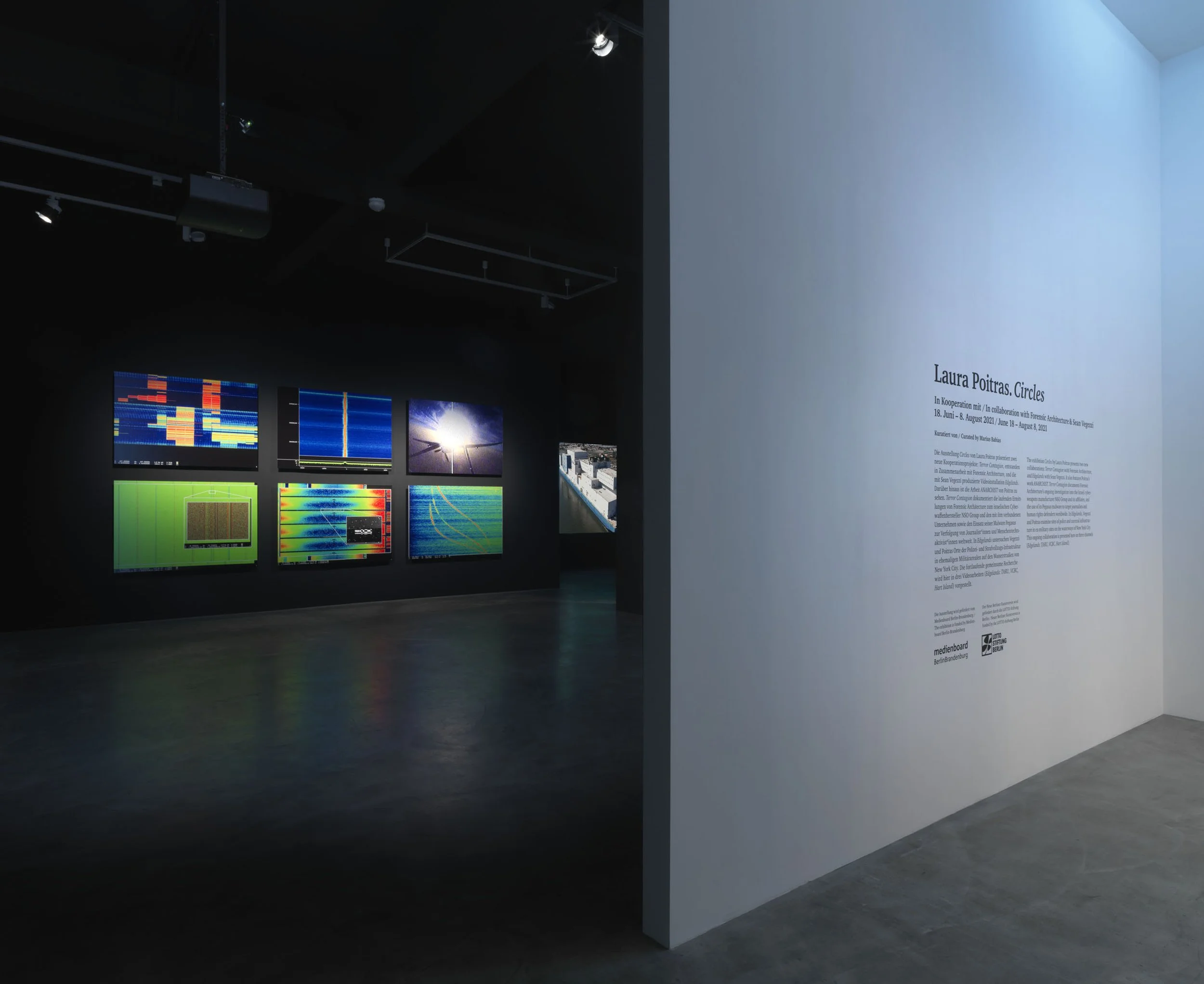 Installation view of the exhibition 'Laura Poitras, Circles' featuring aluminum prints of abstract colorful signals.