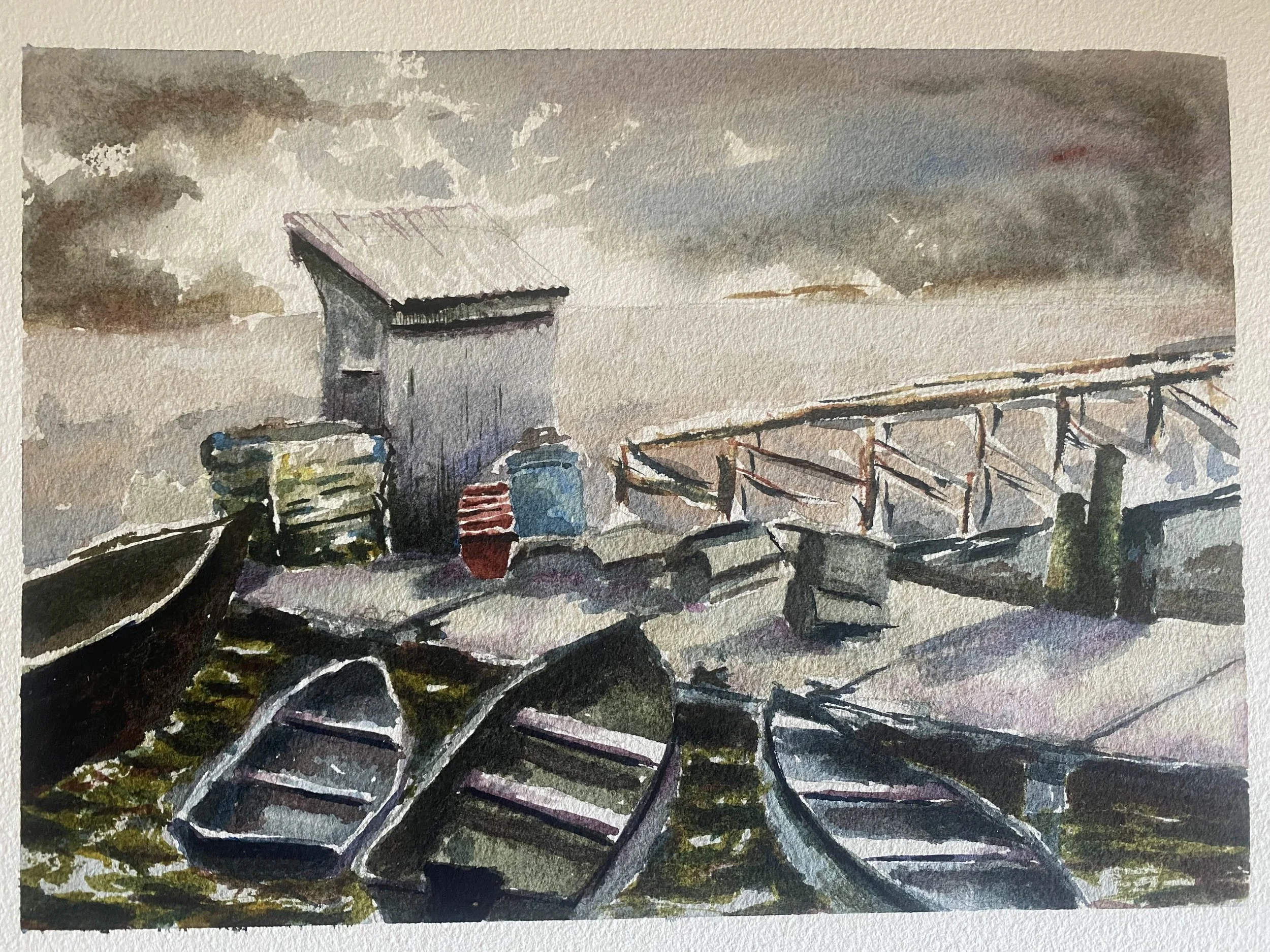 Watercolor painting of a dock area with boats, a small shed, and a cloudy sky in the background.