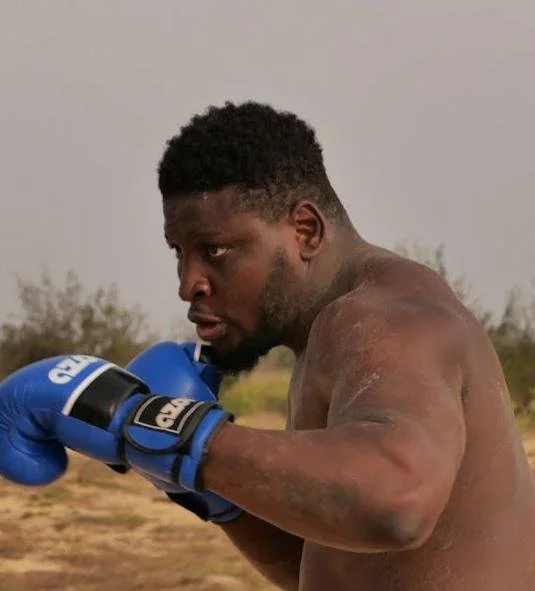 Bullzoder Malika senegalese wrestler wearing blue glove in boxing stance