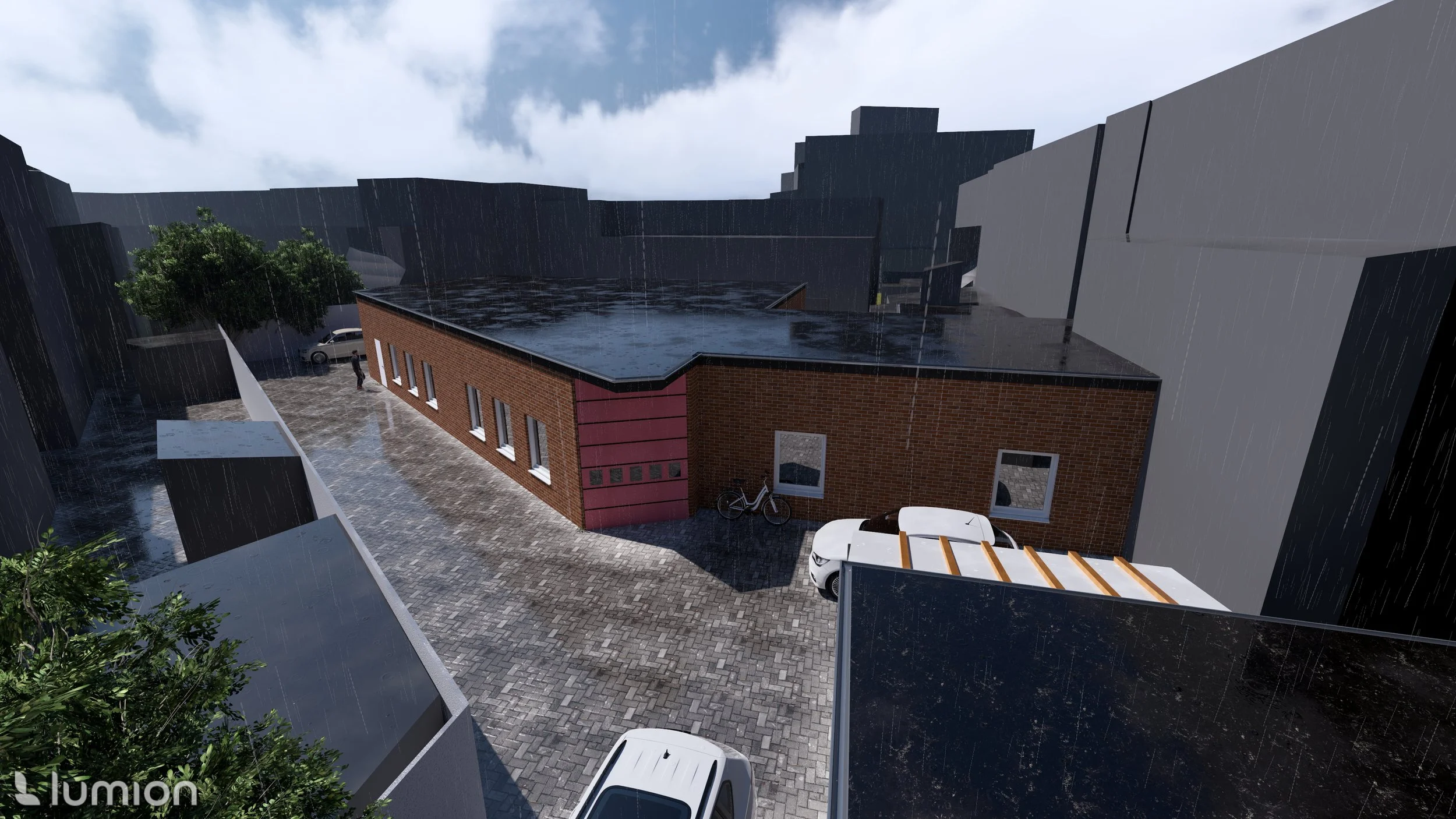 Een beeld van een moderne bouwproject met een rood bakstenen gebouw, een parkeerplaats met auto's en fietsen, en een betonnen muur in de regen op een bewolkte dag.