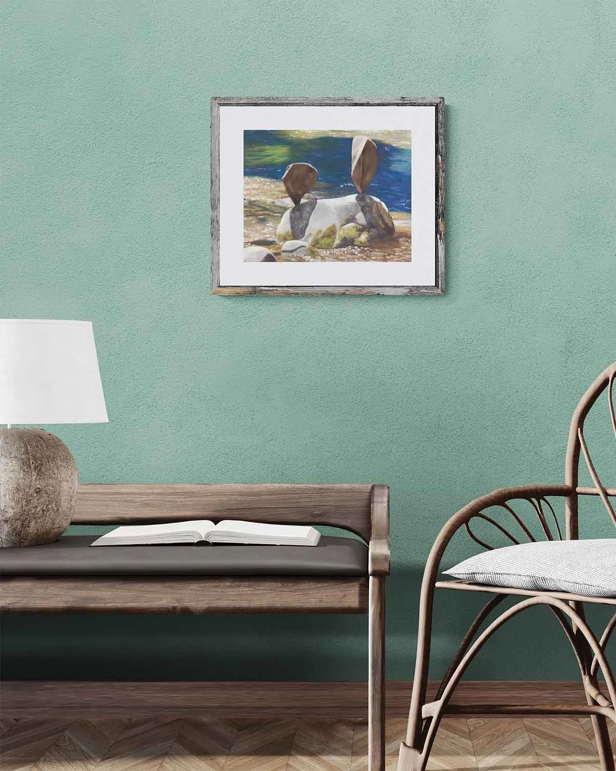 A framed oil pastel painting of rock balancing in a stream in Vail, Colorado.