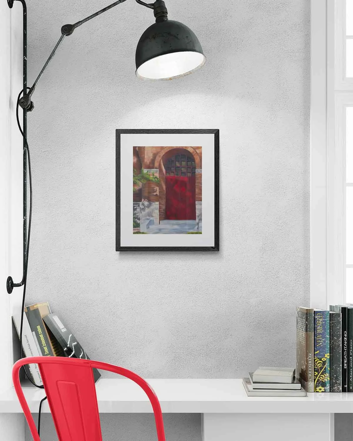 A framed oil pastel painting of a red door on the side of a brick building.