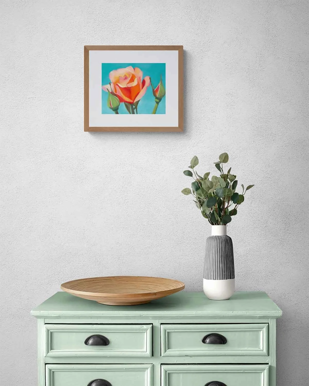 A framed oil pastel painting of an orange rose against a blue sky background.