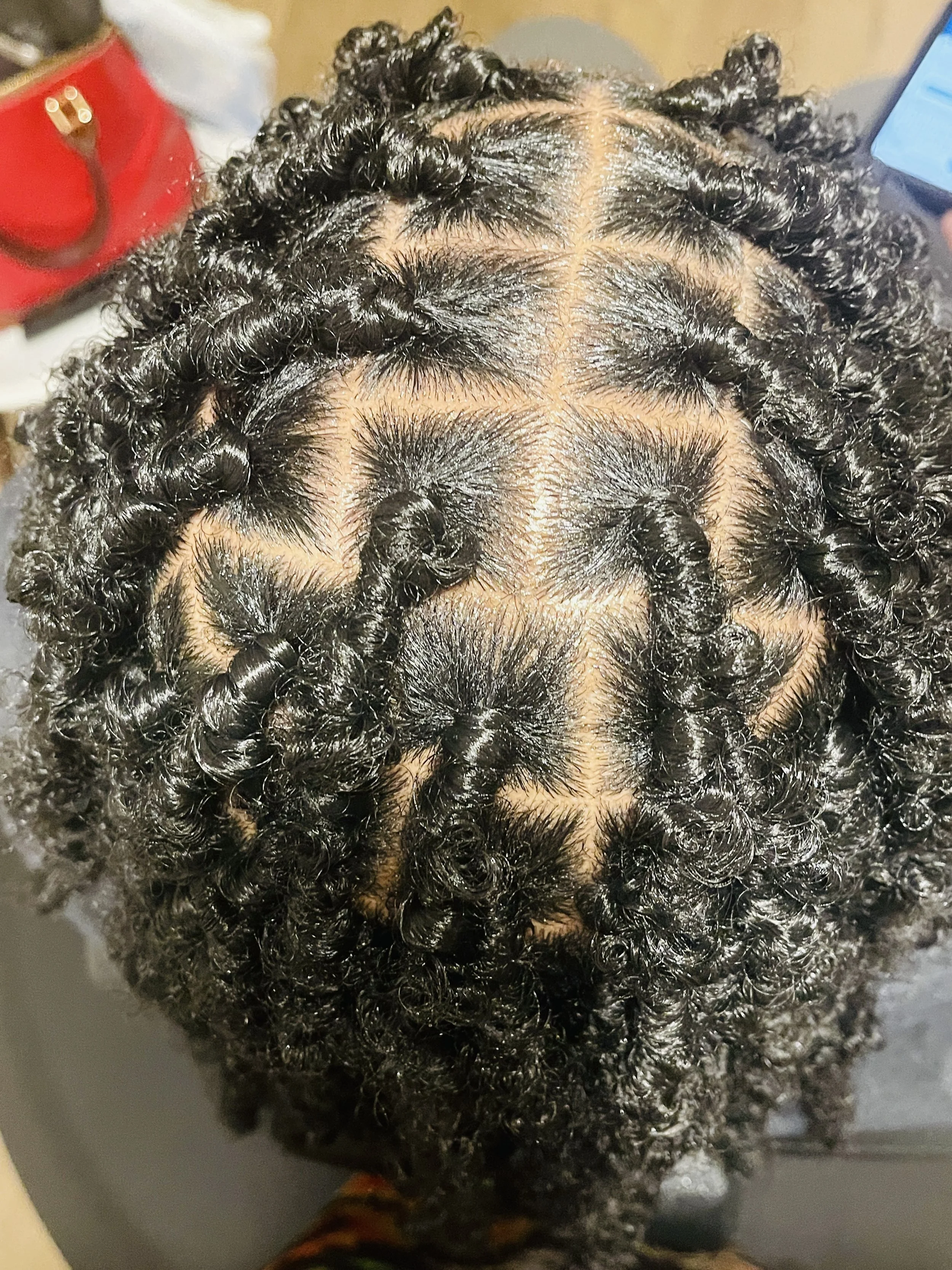 Top view of tightly coiled natural black curly hair.