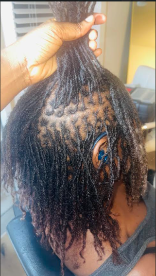 Person with natural curly hair getting a twist out style in a salon