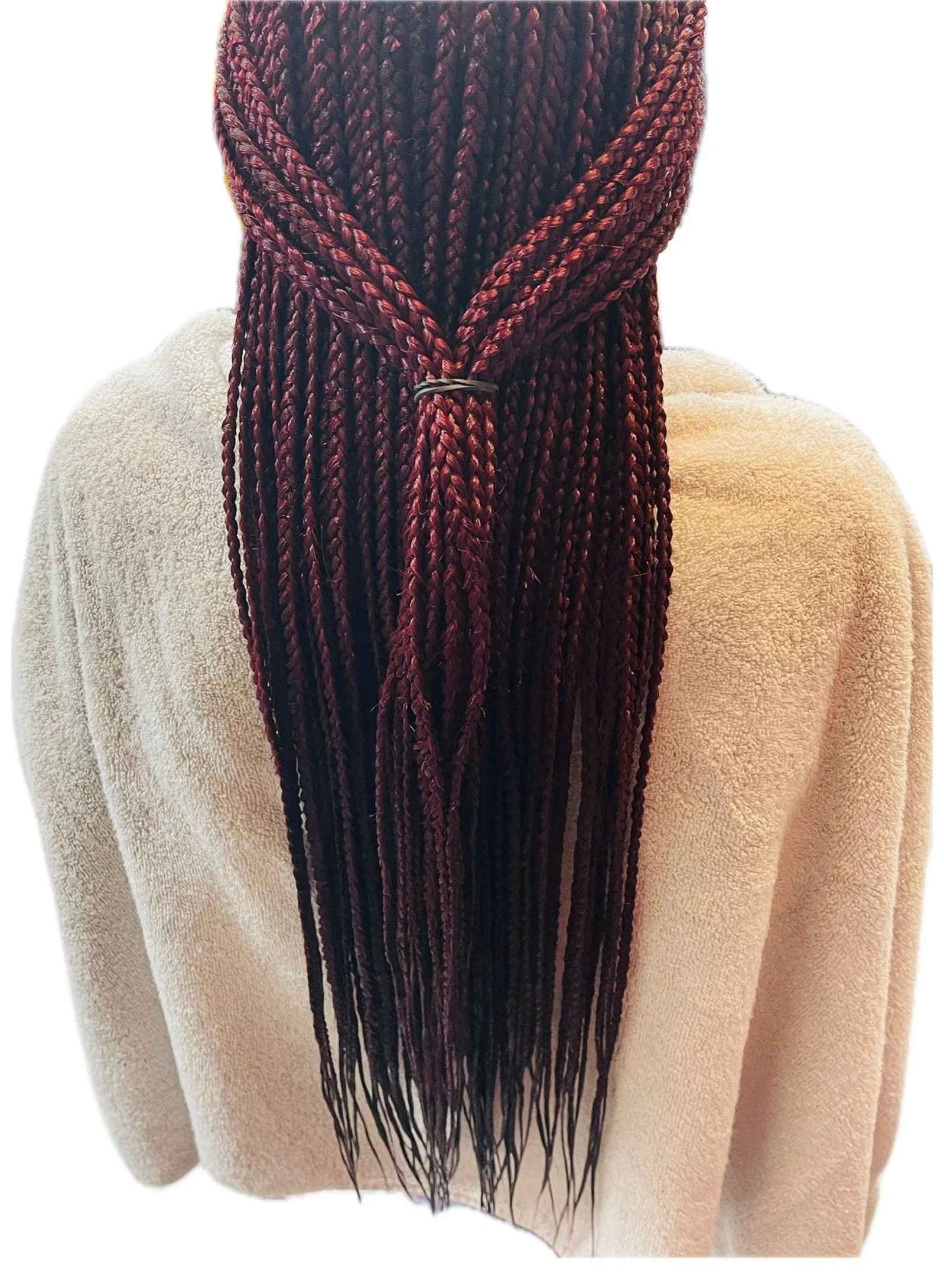A close-up of a person with long braided hair pulled together with a silver hair band, wearing a beige fuzzy sweater.