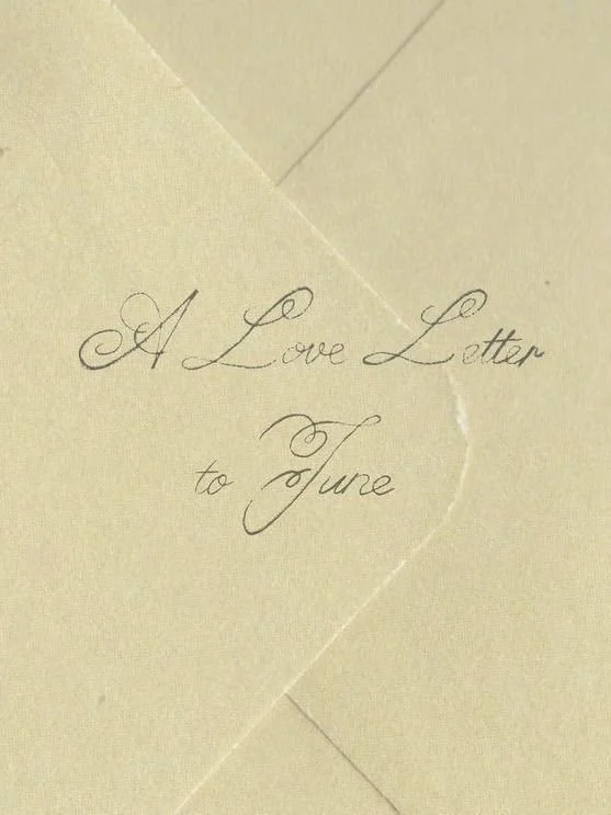 Close-up of an elegant handwritten note on beige paper that says 'A Love Letter to June'.