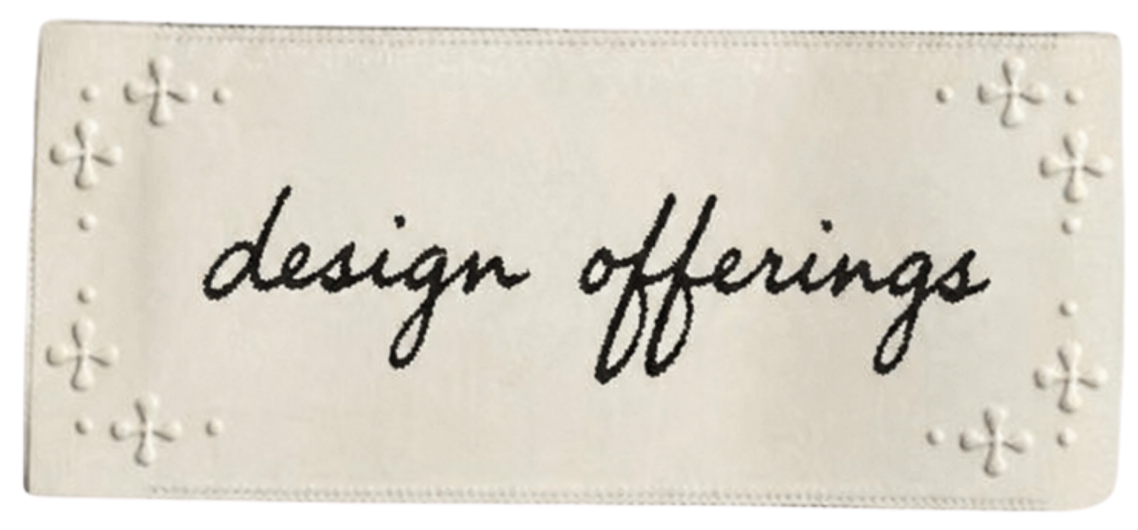 A decorative white card with embossed cross designs on the border and the handwritten phrase 'design offerings' in the center.