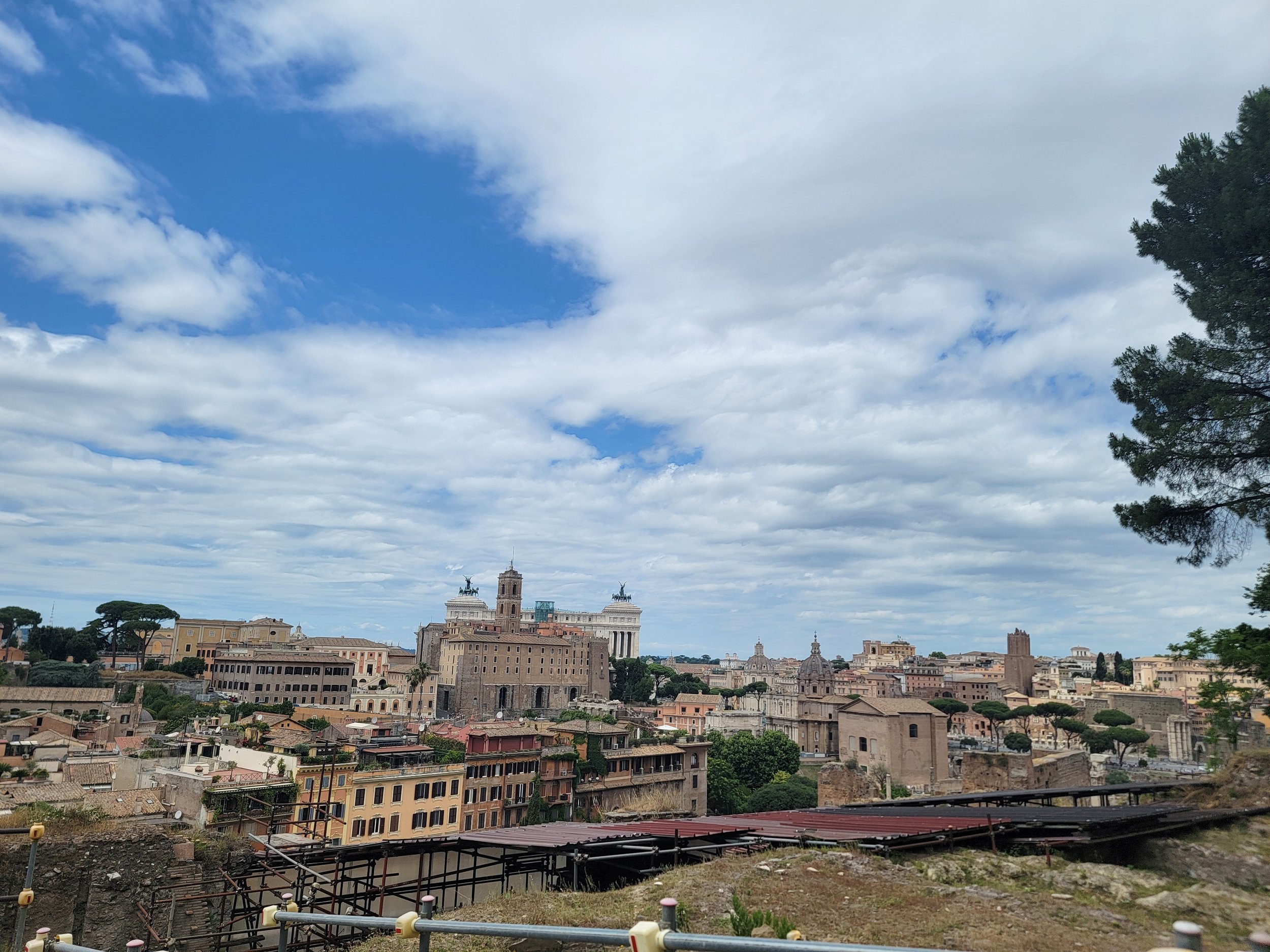 View of Rome cityscape with historic buildings and clouds in the sky.