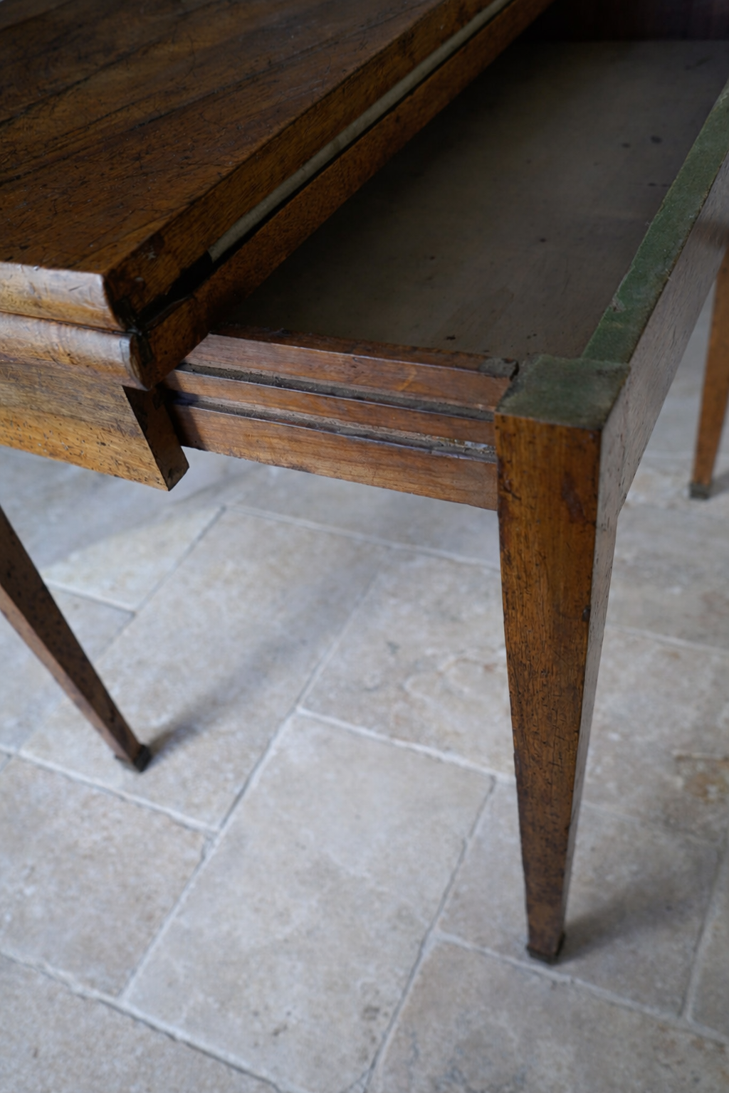 Worn wooden table with green trim.png
