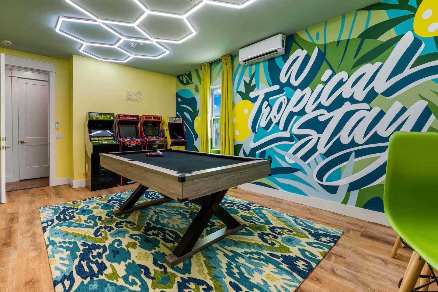 Game room with TV, pool table, arcade games, and bar seating at Panama City Beach rental