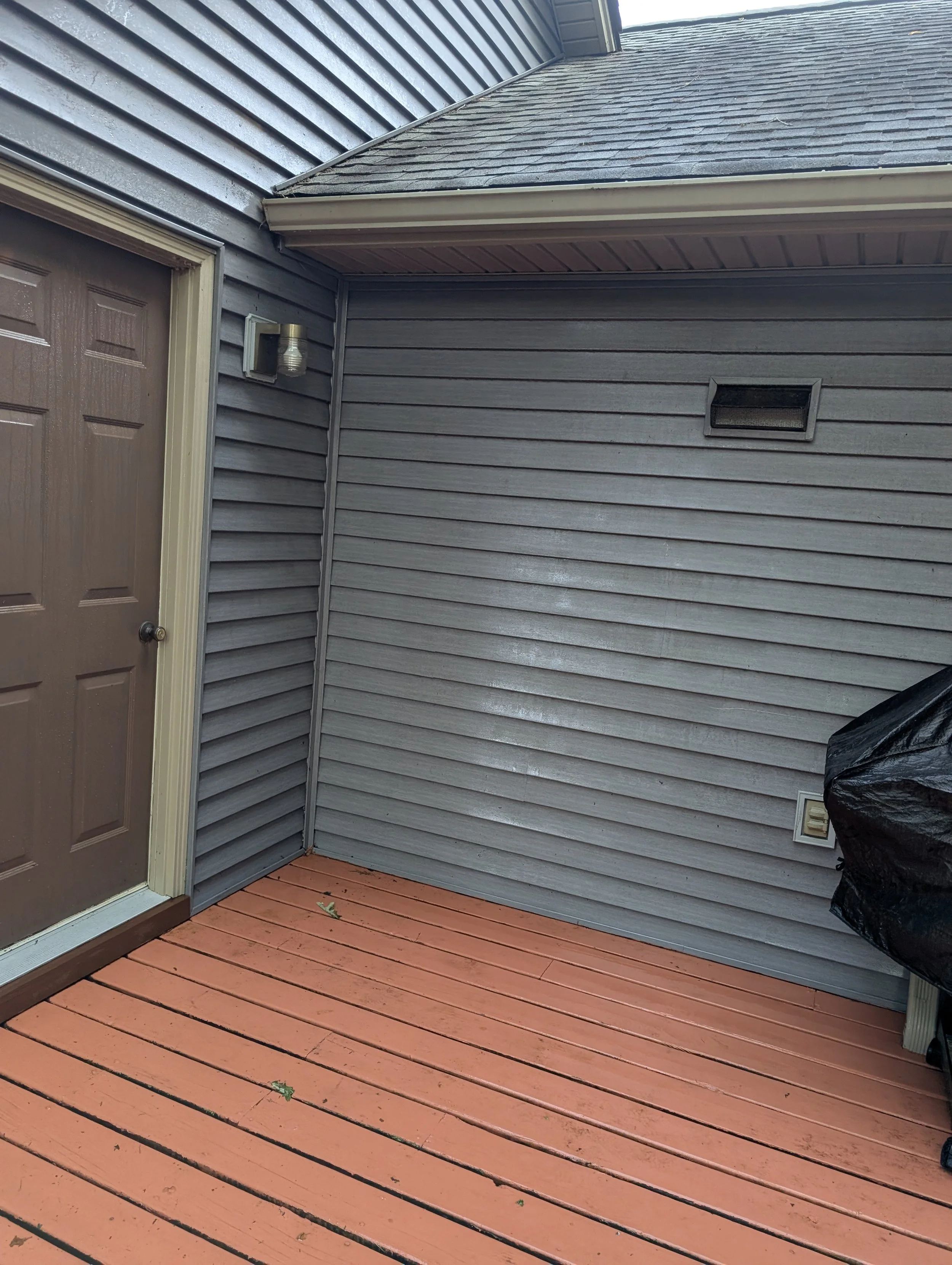 Image of freshly cleaned siding and a freshly pressure washed deck which is painted red.