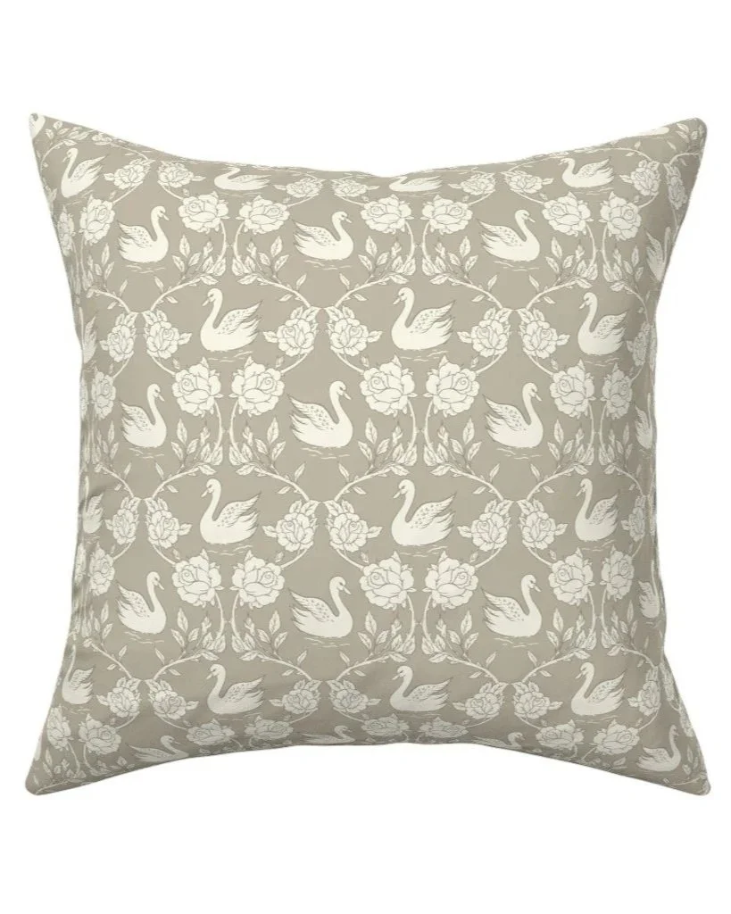 Decorative throw pillow with a pattern of swans and flowers in a neutral color palette. Showing an example of how my artwork may be applied to a pillow.