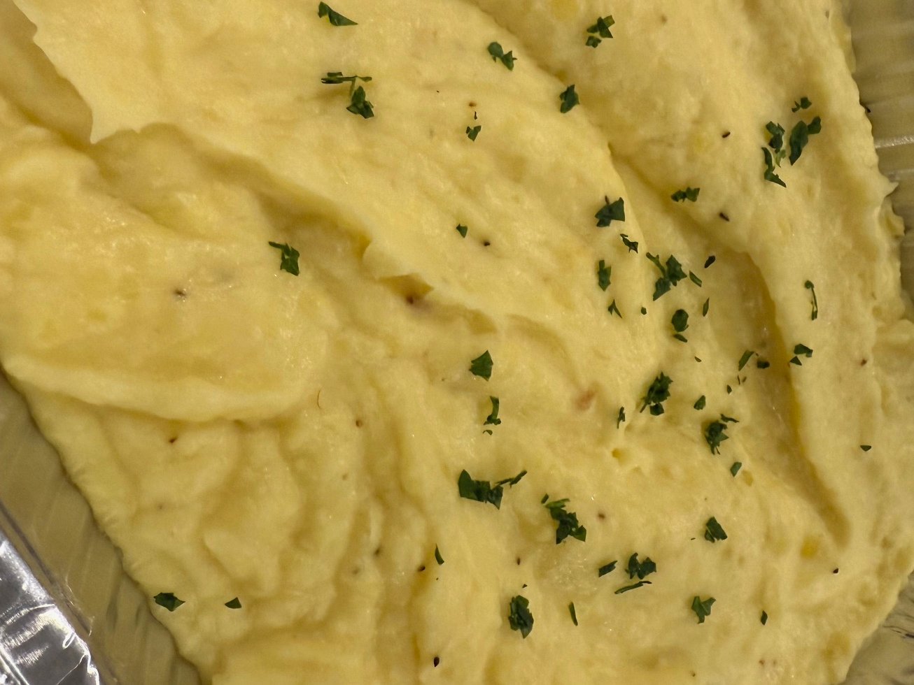 Close-up of mashed potatoes topped with chopped parsley.